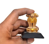 Golden resin Ashoka lion figurine with coin emblem base on a dark stand