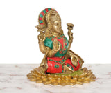 Brass Lakshmi idol profile, teal drape and red waistband with circular jewel details