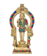 Brass Lord Kartikeya Murugan idol standing, ornate arched backdrop, colorful jewel robe