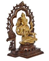 Brass Lakshmi idol with halo arch, one hand raised, seated on lotus pedestal