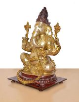Brass Ganpati Bappa idol three-quarter view, gold body, red crown, holding symbolic items