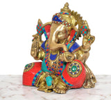 Brass Ganpati Bappa murti close view with gold face, multicolor garments, and hands