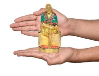 Brass Sai Baba statue held in hands, seated figure with green robe