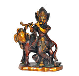 Krishna with cow figurine playing flute, dark metal finish with gold accents