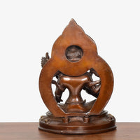 Brass Tara Devi statue rear view, ornate oval halo and seated form on base