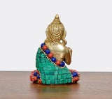Meditating brass Buddha statue, close-up side, green sash and colorful bead necklace
