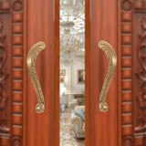 Brass main door pull handle pair, ornate curved grips in golden finish.