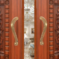 Brass main door pull handle pair, ornate curved grips in golden finish.
