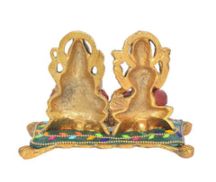 Back view of Laxmi-Ganesh metal diya with raised detailing and colorful base