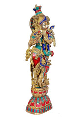 Brass Krishna murti with elaborate gold frame and colorful garments, front-left profile stance