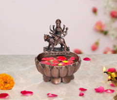 Copper Durga Maa urli bowl with seated deity statue and flower petals in top cup