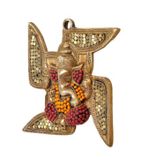 Brass Ganesha swastik wall hanging, side view with red bead clusters and gold dots
