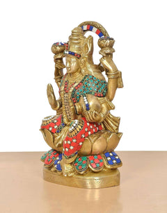 Brass Lakshmi idol seated on lotus base, side view with colorful trim