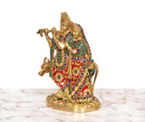 Side view of Radha-Krishna brass idol with cow, multicolored ornate outfits