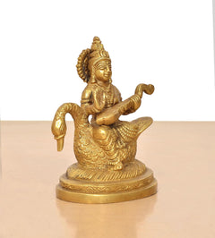 Brass Saraswati idol on swan, side view of veena and layered garment details