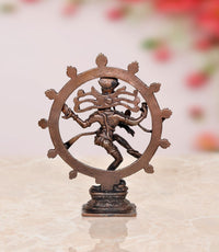 Back view of copper Nataraja Shiva idol inside circular halo, standing on pedestal