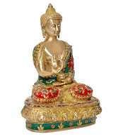 Brass Buddha statue, three-quarter view, gold face, green robe with red flower accents