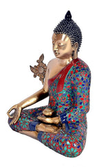 Seated Buddha sculpture, brass tone with dark beaded ushnisha, floral robe on the lap