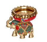 Brass elephant statue with red urli bowl, teal and green patterned body decor