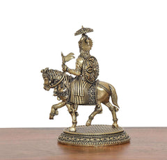 Brass horse rider idol, back view with decorative armor and shield, on round base