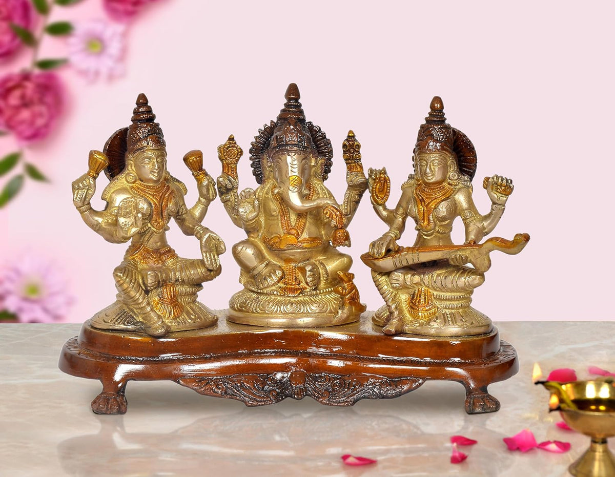 Brass-gold Lakshmi, Ganesh, and Saraswati idol with raised hands on round pedestal