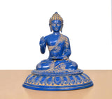 Blue brass Buddha statue seated with one hand raised, gold patterned robes