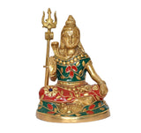 Brass Shiva idol figurine seated with trident, golden face and jeweled teal-red outfit