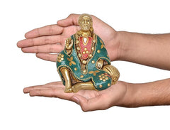 Sai Baba brass statue held in hands, teal robe with gold beads and red pendant
