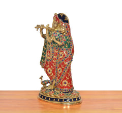 Side view of brass Radha Krishna idol holding flute, multicolor embroidered robes