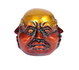 Close-up Buddha showpiece face, gold head with red-brown patina