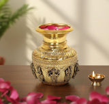 Brass kalash showpiece with raised deity figures and lotus-shaped top, 7 inch height