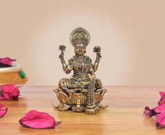 Brass Lakshmi deity murti seated on lotus, ornate crown and raised hands