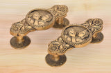 Brass door handle pair, two-god & goddess motifs on oval plates with round bases