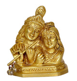 Radha Krishna murti close-up, gold-tone figures with detailed faces and crown