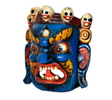 Front deity wall mask with blue skin, circular eyes, red fanged grin, skull details