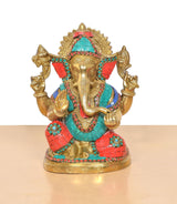 Ganpati Bappa murti close-up: gold face, red and teal mosaic panels, jeweled crown