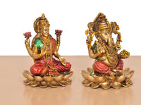 Resin Lakshmi and Ganesh statues sitting on lotus petals, angled side view