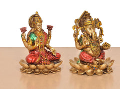 Resin Lakshmi and Ganesh statues sitting on lotus petals, angled side view