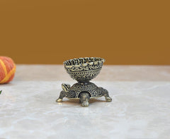 Brass tortoise oil lamp diya with engraved body and standing legs, angled view