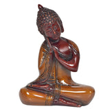 Brass meditating Buddha idol with red and bronze finish, clasped hands