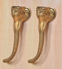 Brass Ganesha face door handle pair, gold finish, textured ridges on curved grips