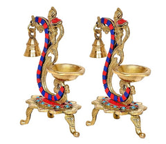 Two brass peacock bell diya stands with blue-red enamel stripes and jeweled circular base
