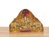 Brass Ganesha idol with elephants, front view, red and gold painted accents