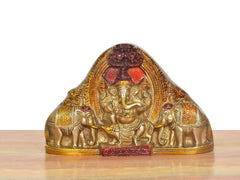 Brass Ganesha idol with elephants, front view, red and gold painted accents