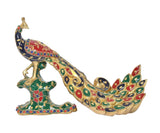 Brass peacock sculpture showing blue body, red accents, and decorated pedestal