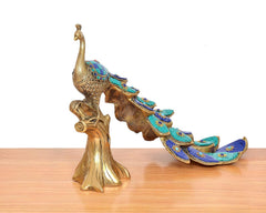 Brass peacock showpiece, angled view showing long tail and decorative base