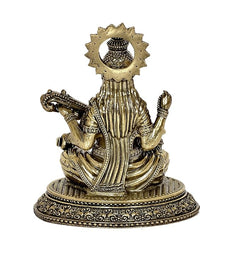 Back view of brass Saraswati idol, decorative halo, veena and seated pedestal