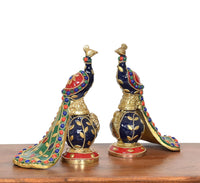 Close view brass peacock figurines with dark blue body, gold scales, multicolor trim