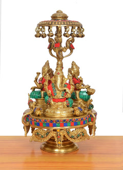 Brass Lakshmi-Ganesha-Saraswati idol with parasol canopy and jeweled rim, multicolor