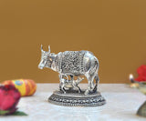 Brass cow with calf figurine, side view, ornate panel detailing